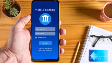Hand holding a phone open to a mobile banking app, representing the Chime banking review