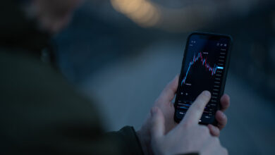 Trader monitoring stock market charts on screens while reviewing the Robinhood investing app